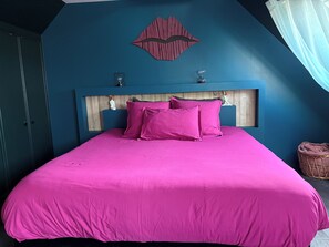 A bedroom with a bed, a wooden headboard, a wall decoration, and a window with curtains. - Ker Love Rennes Nature maison 4 personnes (Laillé)