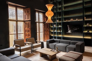 A modern living room with a sofa, chairs, a coffee table, and a bookshelf. - Vrbo Property (Cartagena de Indias)