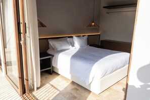 A bedroom with a bed, bedside tables, and a window. - Casa Alquimia—8 bedrooms (Cartagena de Indias)