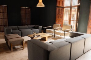 Een moderne woonkamer met een hoekbank, een salontafel en een bijzettafeltje.