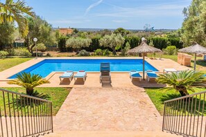 A rectangular swimming pool with lounge chairs and a thatched umbrella. - Holiday Home 'Can Bou' with Sea View, Wi-Fi and Air Conditioning (Ses Salines)