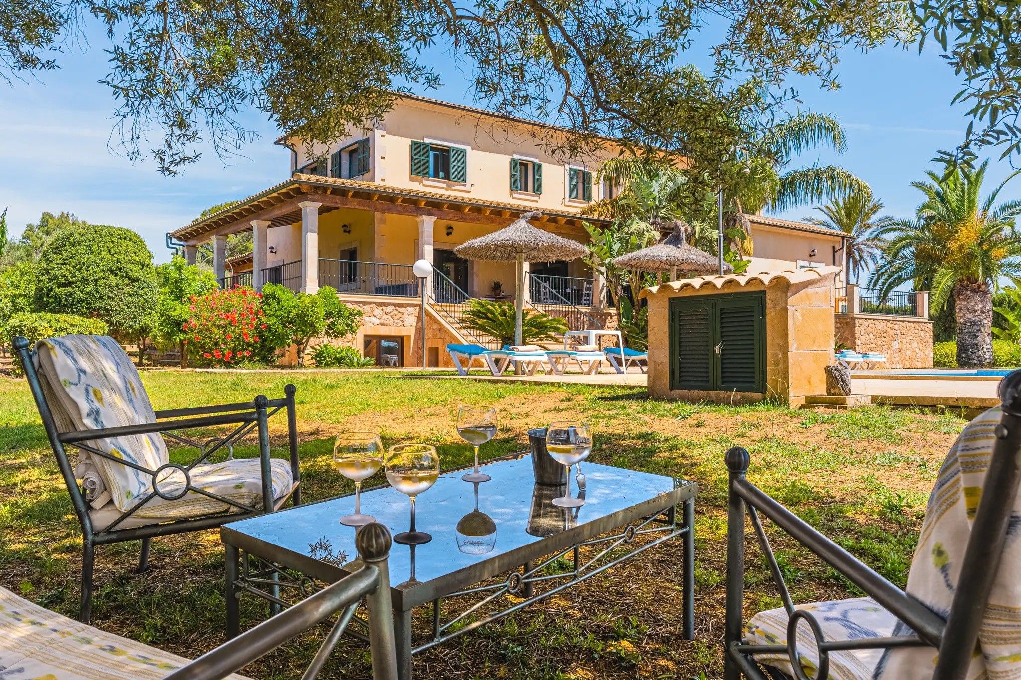A villa with a pool, outdoor seating, and a covered patio area.