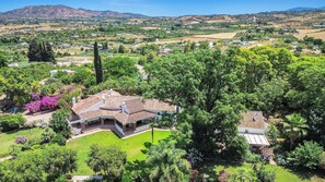 A house with a tiled roof, surrounded by lush greenery and a well-maintained lawn. - Private villa with a large pool and guest house | Casa J&J | Andalusia (Alhaurín el Grande)