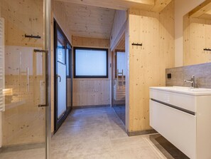 A modern bathroom with a large mirror, a white sink, and wooden paneling. - Superior Chalet # 9 With Sauna & Hot Tub (Stadl-Predlitz)