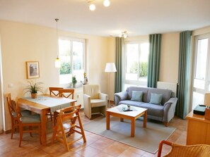 A well-lit living room with a dining area, a sofa, and a coffee table. - Apartment Building Linquenda 09 (Heringsdorf)