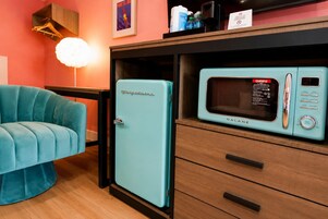 A compact kitchen with a vintage-style refrigerator and a microwave.