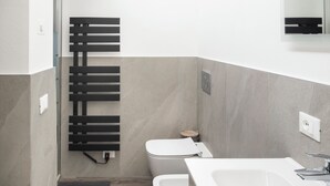 A modern bathroom with a toilet, bidet, and a large sink. - Vrbo Property (Montichiari)