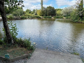 A calm river with a concrete walkway alongside.