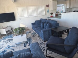 Una sala de estar con un sofá, una mesa de centro y un televisor.