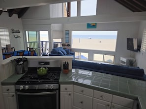Una cocina con estufa, horno y comedor con vista a la playa.