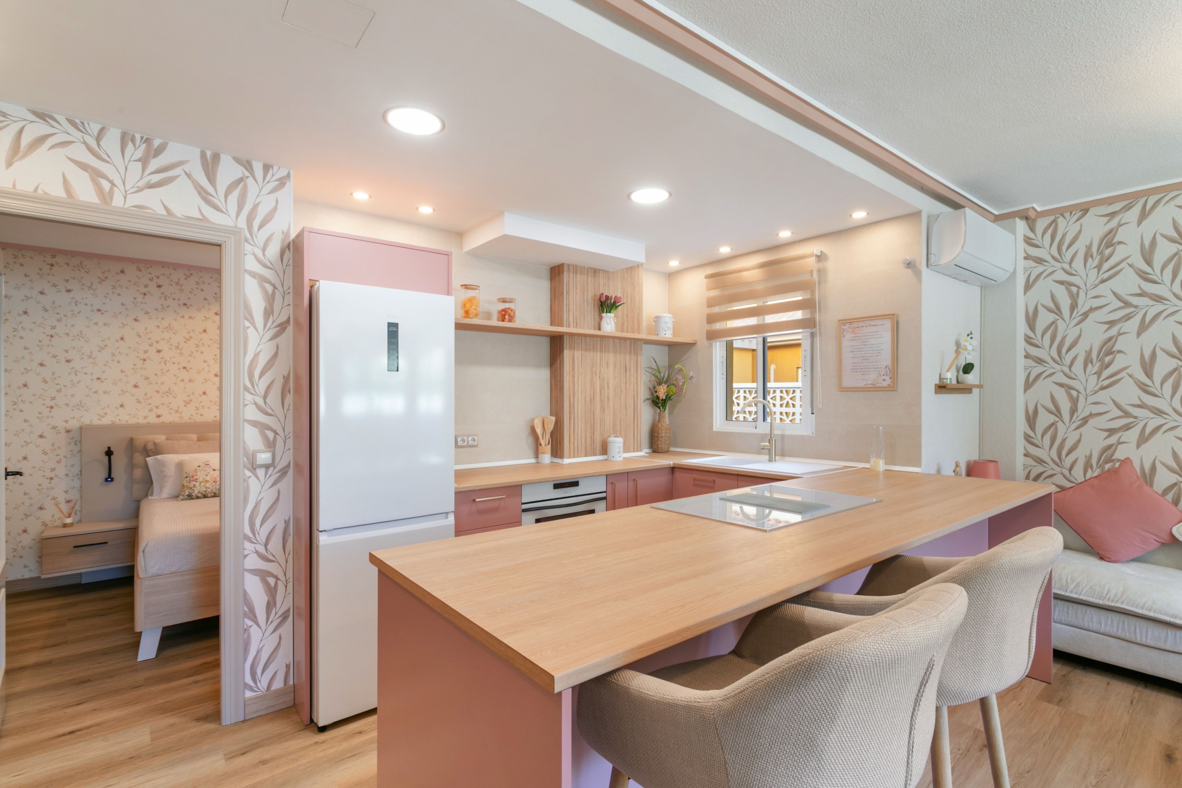 Een moderne keuken met een centraal eiland, houten kastjes en een inbouwkoelkast.