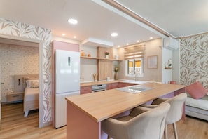 Een moderne keuken met een centraal eiland, houten kastjes en een inbouwkoelkast.