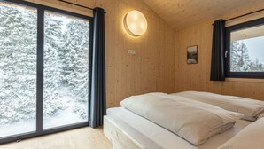 A room with a bed, a window, and a wall-mounted light fixture. - Cabin in Turrach With Balcony and Wi-fi (Stadl-Predlitz)