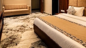 A hotel room with a large bed, a sofa, a marble floor, and a wooden headboard. - The Lalan Palace (Udaipur)