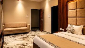 Een hotelkamer met een groot bed, een bank, een marmeren vloer en een houten hoofdeinde.