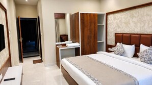 A hotel room with a bed, a wardrobe, a vanity with a mirror, and a television. - The Lalan Palace (Udaipur)
