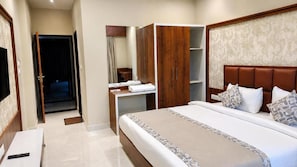A hotel room with a bed, a wardrobe, a vanity with a mirror, and a television. - The Lalan Palace (Udaipur)