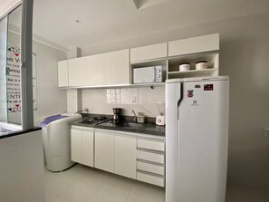 A modern kitchen with white cabinets, a built-in stove, and a refrigerator. - Apartment 304 · 304 2 bedrooms - Stylish and Comfortable (Belém)