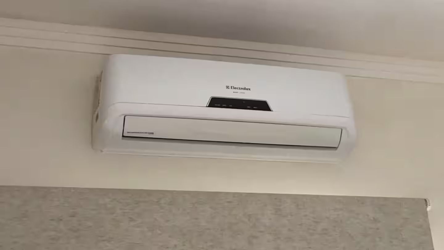 Un climatiseur mural blanc, doté d’un écran numérique et d’un panneau de commande.