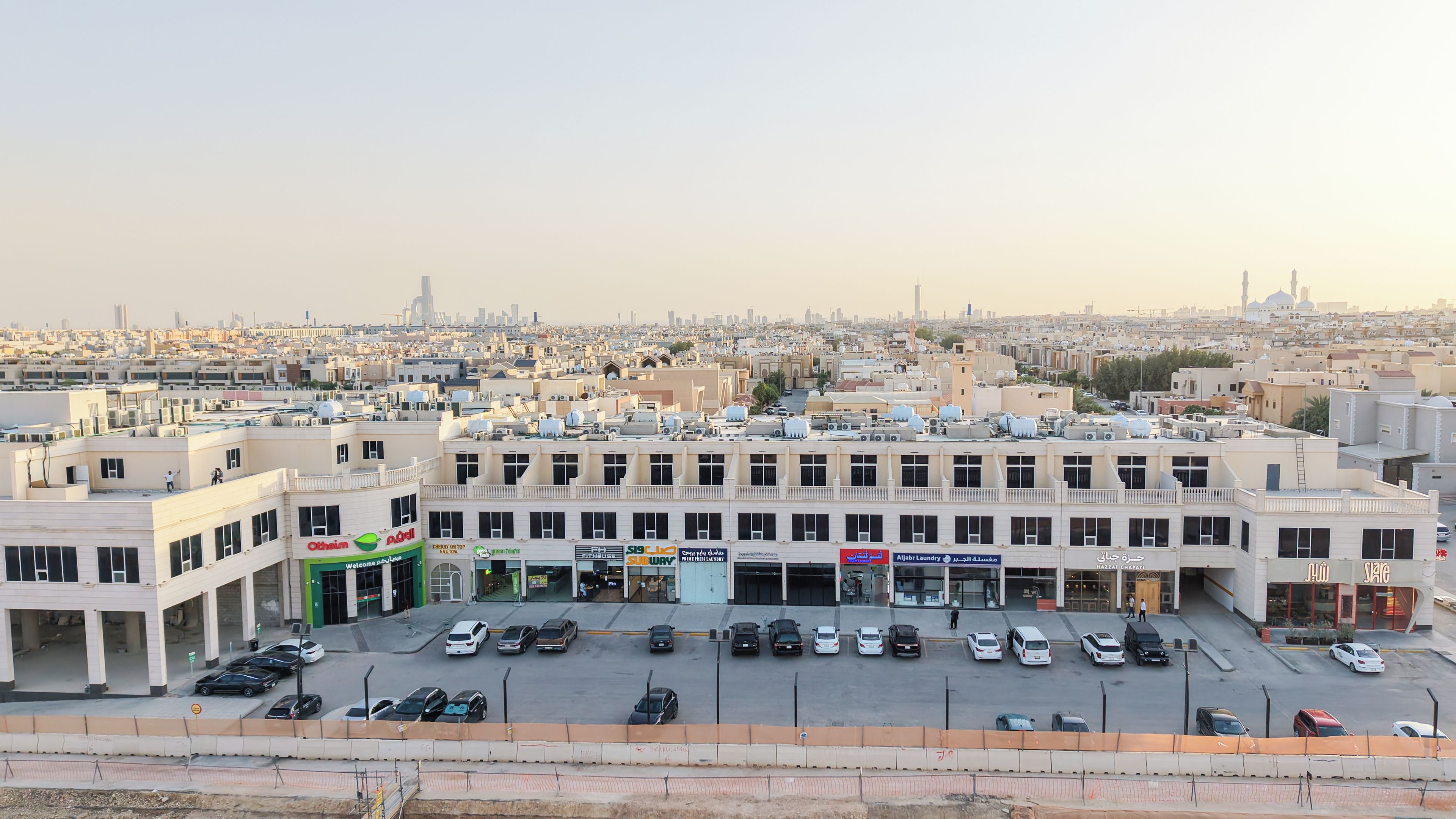 A multi-story building with a parking lot in front.