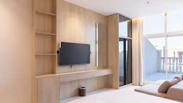 Une chambre d’hôtel moderne dotée d’un grand téléviseur à écran plat fixé sur un mur en bois, d’une petite poubelle et d’un balcon avec vue.