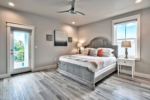 A bedroom with a bed, a ceiling fan, a window, and a door. - King's Castle: Steps to Beach | Heated Pool & Spa | Golf Cart | Game Room (Destin)