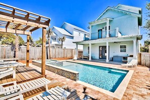 En bostadsfastighet med en swimmingpool, utomhusmöbler och en täckt uteplats.