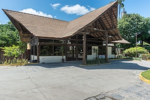 A building with a large, open entrance area and a sloped roof structure. - Nannai Residence Muro Alto Beira Mar (N. Sra. do Ó)