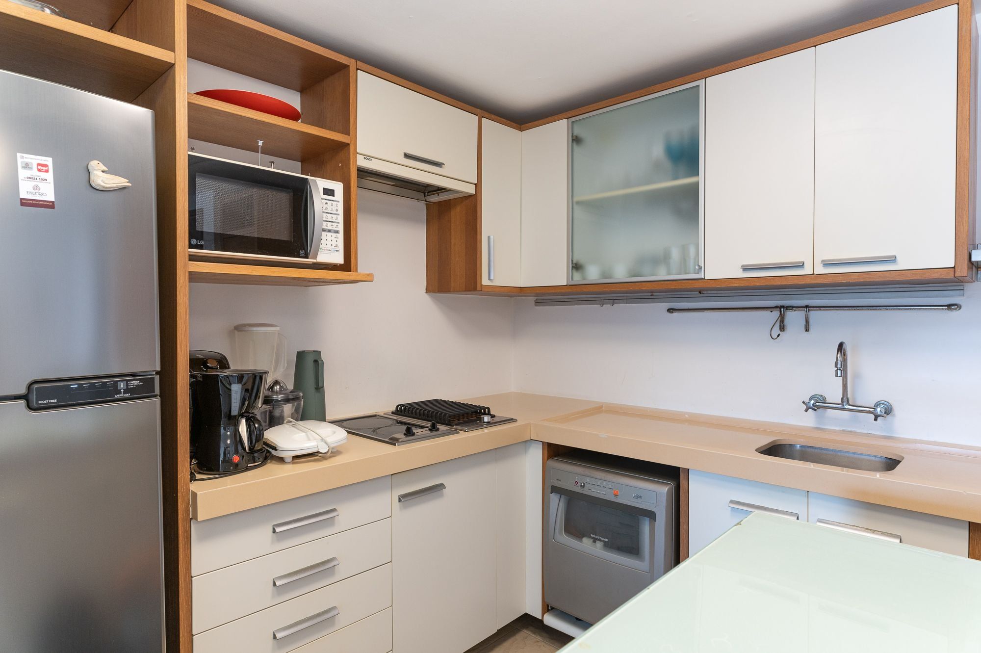 A compact kitchen with a refrigerator, microwave, and dishwasher.
