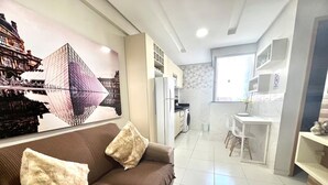 A modern living room with a sofa, a kitchen area, and a dining space. - 305 2 Bedrooms 15 min from the Center (Belém)