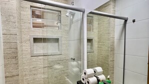 A bathroom with a glass-enclosed shower, a toilet, a sink with a mirror, and a towel rack. - 305 2 Bedrooms 15 min from the Center (Belém)