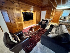 A cozy living room with a flat-screen TV, leather sofa, and a coffee table. - Entire cabin in South Lake Tahoe, California (South Lake Tahoe)