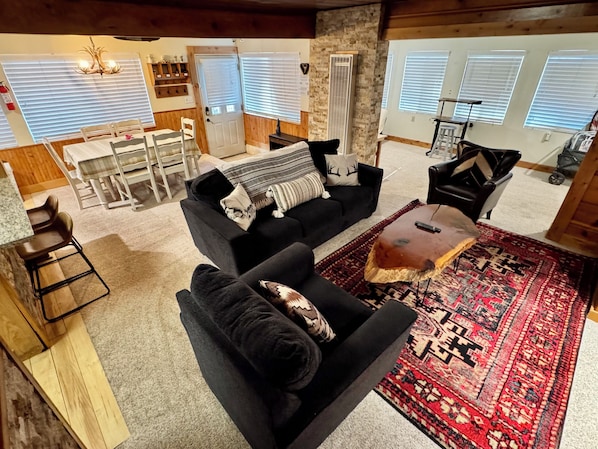 A cozy living room with a black sofa, a coffee table, and a patterned rug.