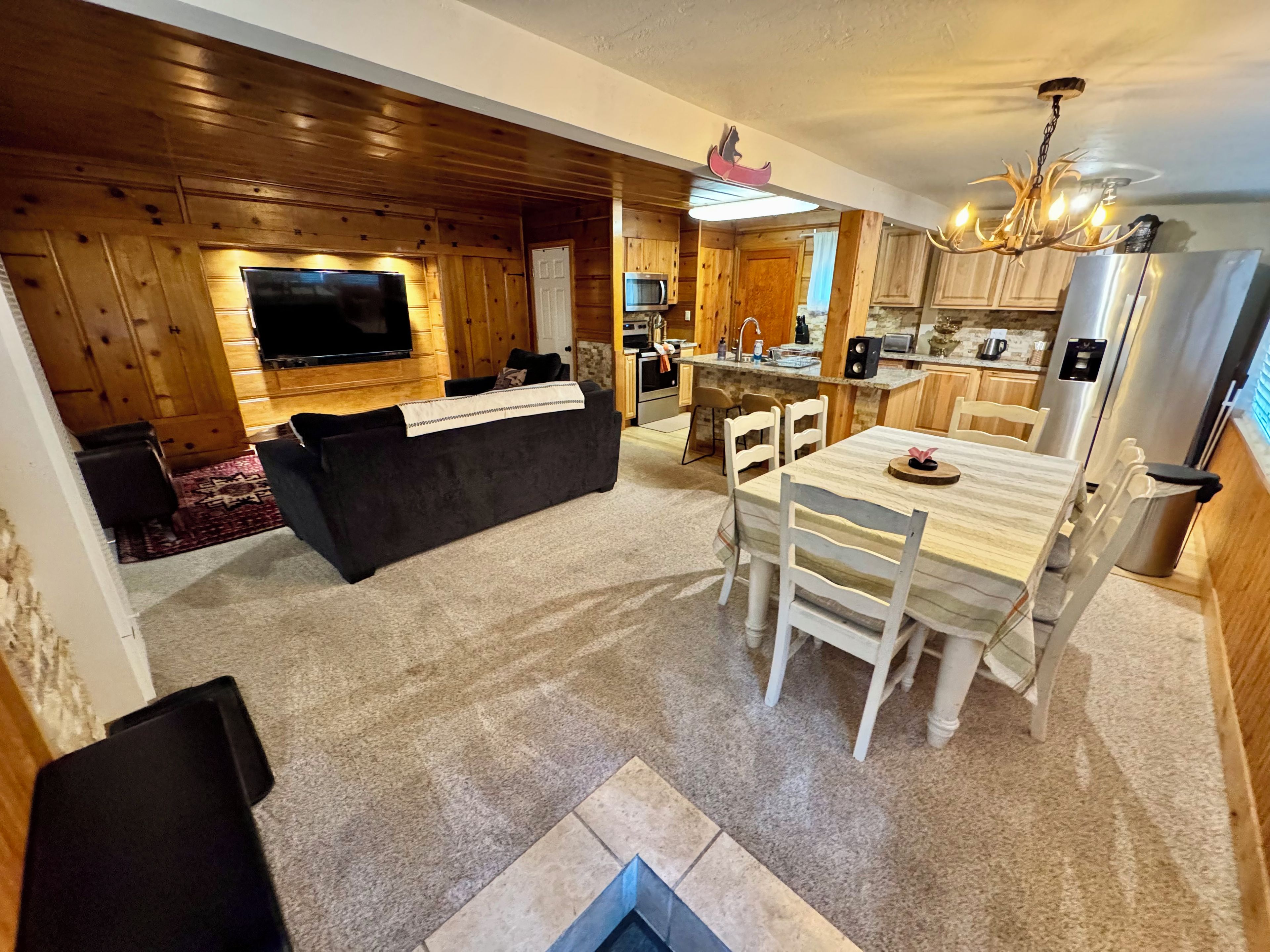 A modern kitchen with wooden cabinets, a dining table, and a built-in oven.