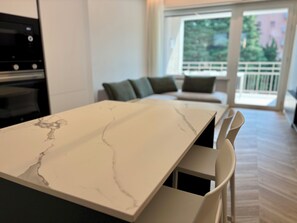 A modern kitchen with a marble countertop and built-in appliances. - Luxurious new apartment with a terrace overlooking the lake on the Sarnico lakeshore. (Sarnico)