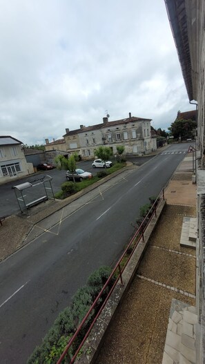 A street view with a building, parked cars, and a pedestrian crossing. - LE CLOS DES VOYAGEURS Bed and Breakfast ALL THE COMFORTS (Saint-Christophe-de-Double)