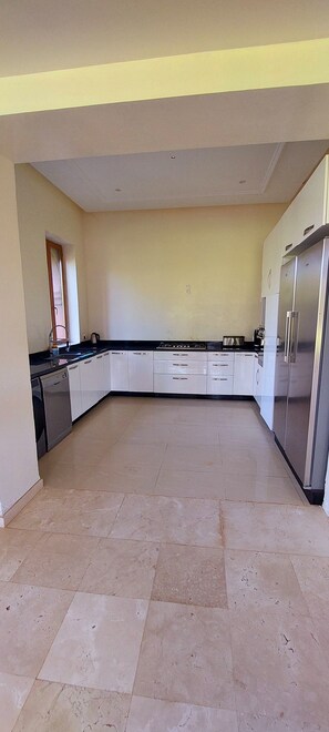 A spacious kitchen with white cabinets, a dishwasher, and a large refrigerator. - Villa Hana Marrakech, with views of the Atlas Mountains, nestled in a 1 ha park. (Sidi Abdellah Ghiat)