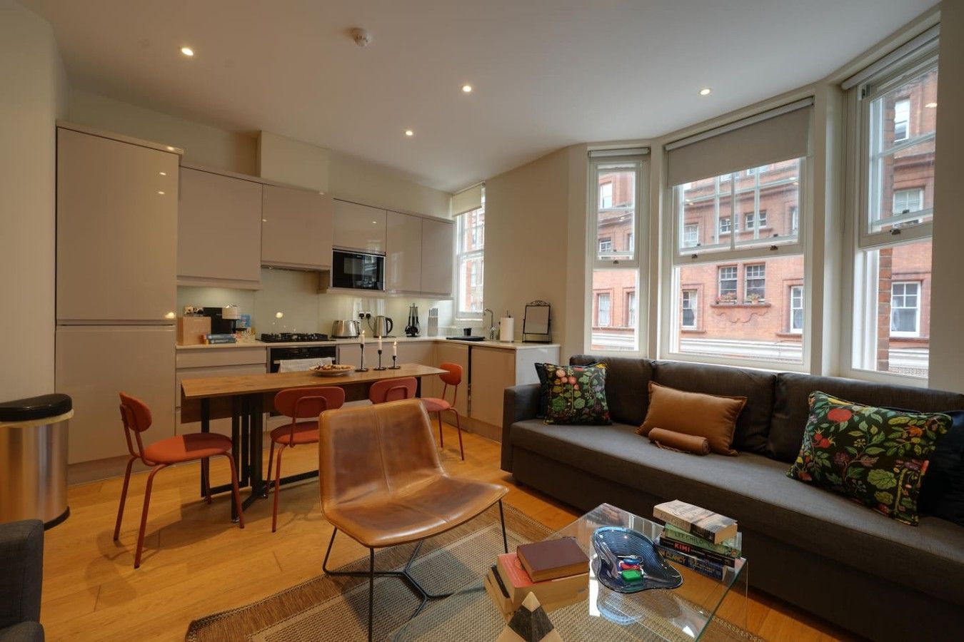 Un espacio moderno para vivir con cocina, comedor y zona de estar con vistas a edificios.