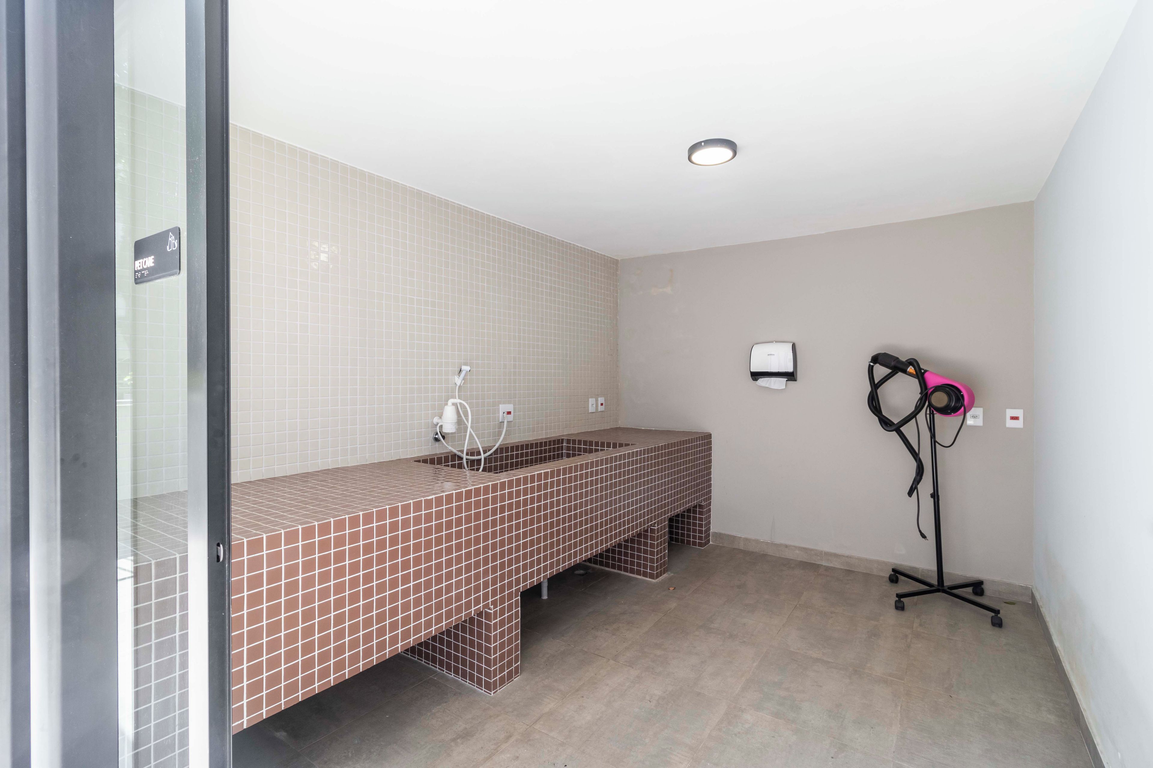 A bathroom with two sinks, a towel rack, and a hairdryer on a stand.