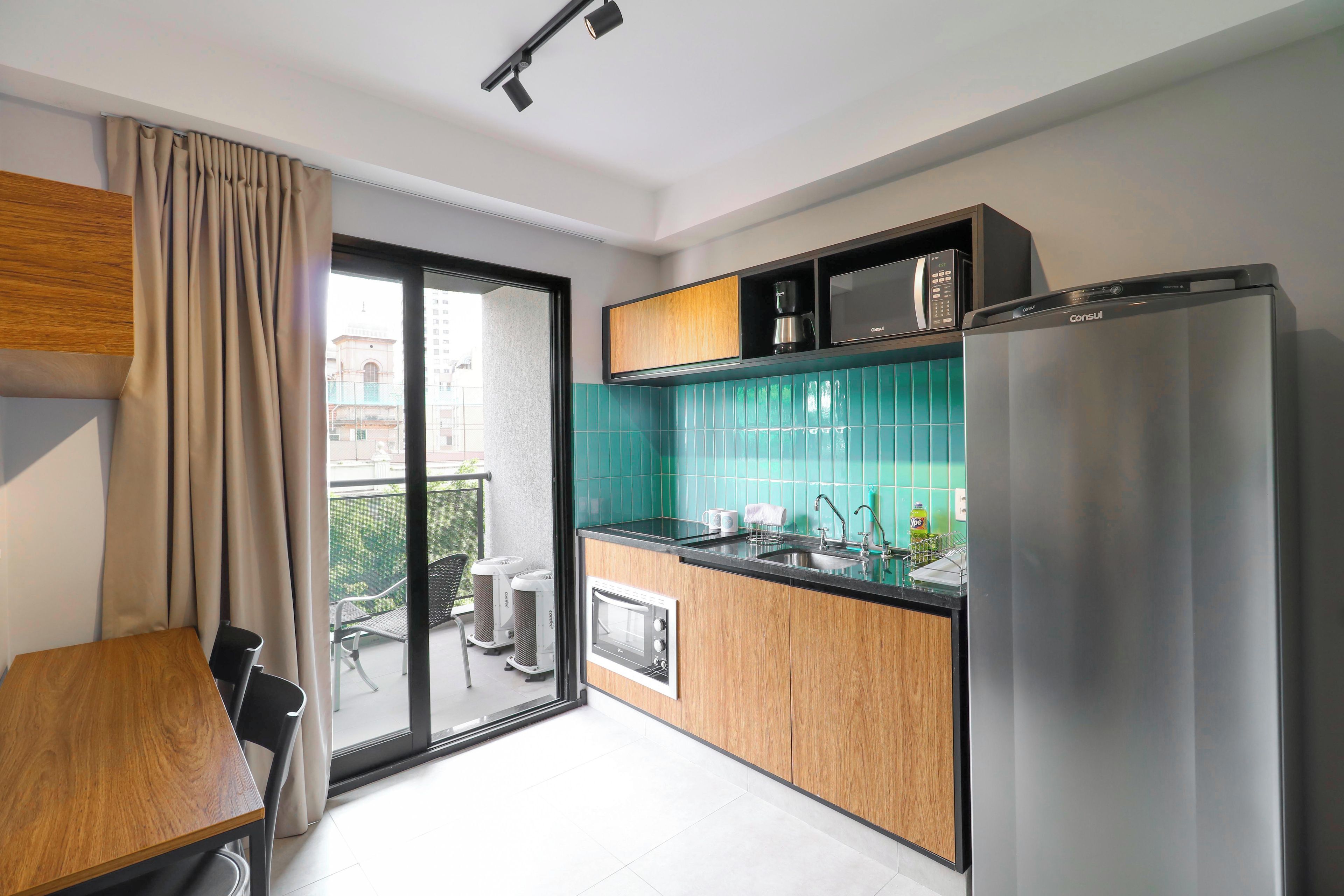 Una cucina moderna con un frigorifero in acciaio inossidabile, una macchina da caffè e un forno a microonde.