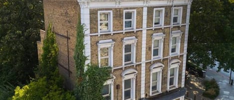 Un edificio de varios pisos con fachada de ladrillo, ventanas grandes y techo plano.