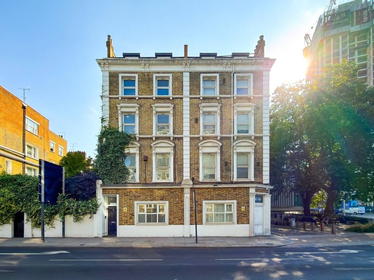 A multi-story building with a brick facade, large windows, and a flat roof.