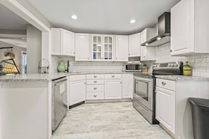 A kitchen with white cabinets, a microwave, an oven, and a sink. - Walk to Saratoga Track | 2 Kings | Pet OK (Saratoga Springs)