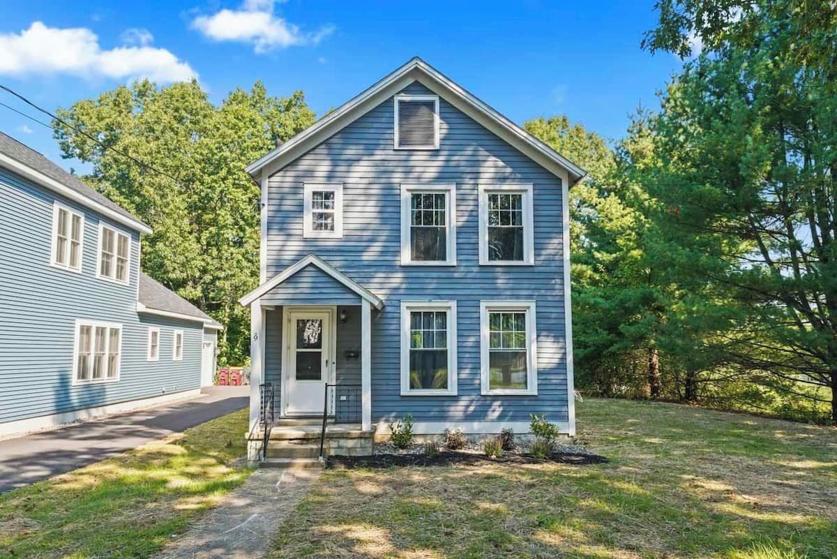A two-story house with a front porch and a small garden.