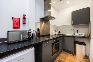 A modern kitchen with a microwave, toaster, and coffee maker. - Earl`s Court Residence | Modern Studio | London (Greater London)