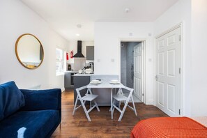 A compact living space with a kitchenette, a dining area, and a bedroom. - Earl`s Court Residence | Elegant Studio | London (Greater London)