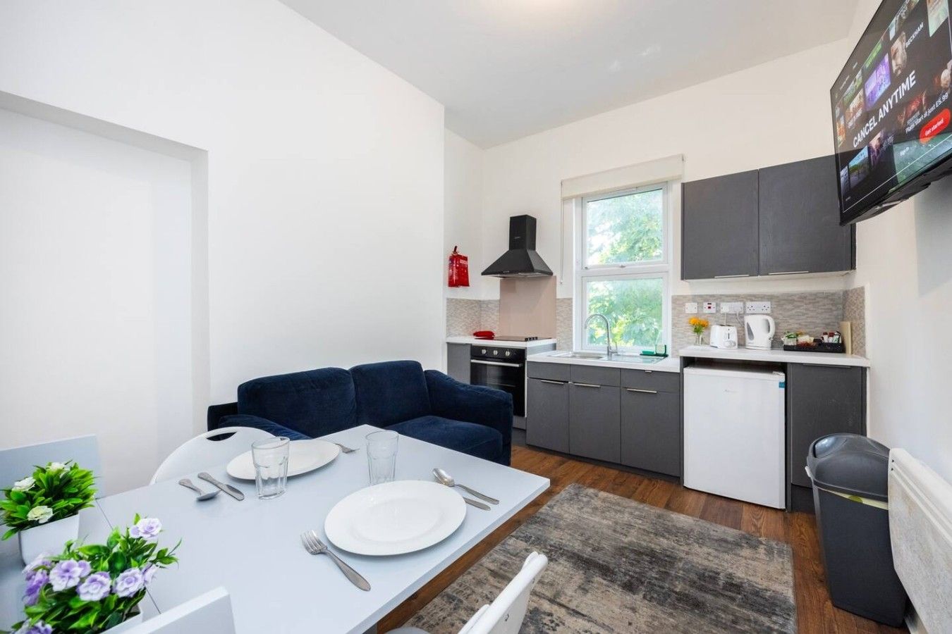 Un espace de vie compact comprenant un coin repas, une kitchenette et un canapé.