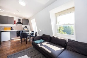A modern apartment with a kitchen, dining area, and a large window. - Earl`s Court Residence | Elegant 2BR | London (Greater London)