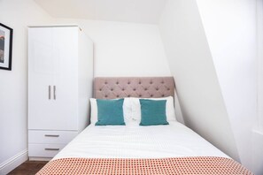 Ein Schlafzimmer mit einem Bett, einem Kleiderschrank und einem Fenster.