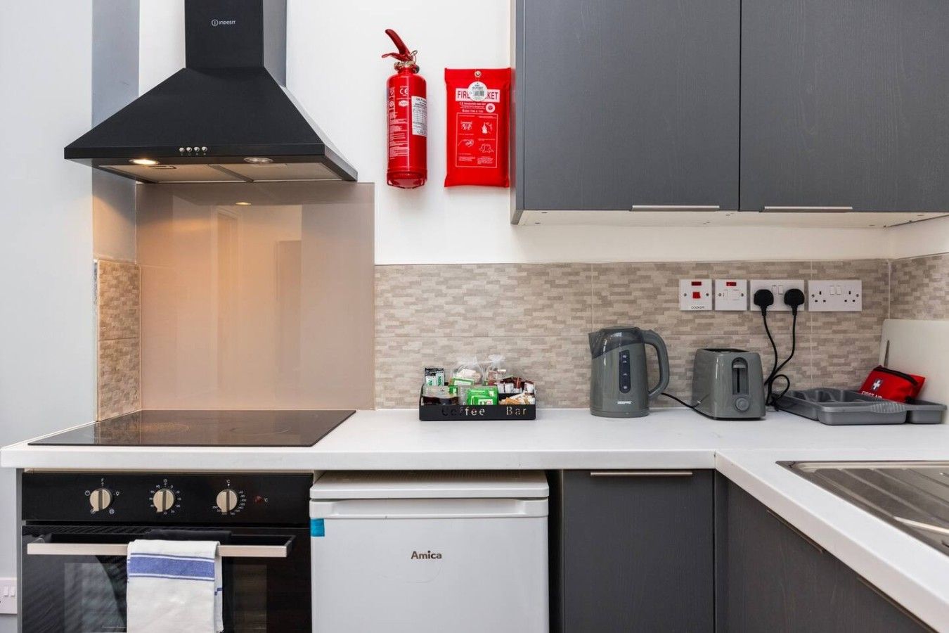 Cozinha moderna com lava-louças, forno e espaço para café.